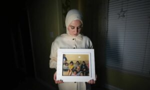 مريم كم ألماز تحمل صورة لولدها الطبيب الأمريكي مجد كم ألماز مع بعض أحفاده- 17 من أيار 2024 (أسوشيتد برس)