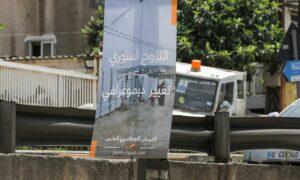 لافتة تحذر من وجود اللاجئين السوريين في لبنان مقدمة من "التيار الوطني الحر" موضوعة على الطريق السريع في جونية بلبنان- 23 من أيار 2024 (رويترز)