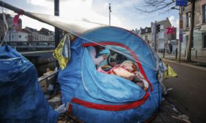 لاجئان يتشاركون مخيم مؤقت خارج مركز استقبال في بروكسل - 17 من كانون الثاني 2023 (AP)