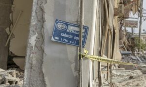 لافتات الشوارع في مدينة هاتاي التركية وسط الأبنية المتضررة من الزلزال - 6 من آذار 2023 (AA)