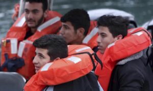 مهاجرون على متن قارب للشرطة القبرصية بعد إنقاذ سفينتهم- كانون الثاني 2024 (AP)