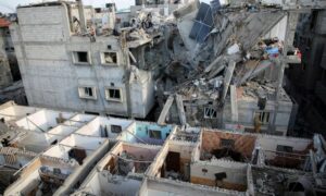 فلسطينيون يتفقدون موقع غارة إسرائيلية  على منزل في رفح جنوبي قطاع غزة- 7 من أيار 2024 (رويترز)