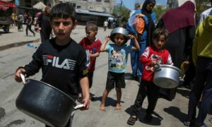 أطفال فلسطينيون بانتظار الحصول على الطعام في ظل شح المساعدات جراء إغلاق إسرائيلي للمعابر البرية والتوجه نحو عملية عسكرية إسرائيلية في رفح- 8 من أيار 2024 (رويترز)