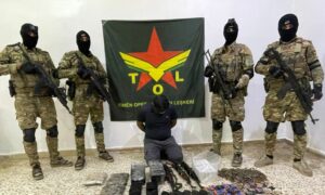 مقاتلون من قوات سوريا الديمقراطية يستعرضون زعيم تنظيم الدولة في الرقة وأسلحة ضبطت بحوزته بعد اعتقاله في عملية أمنية شمال شرقي سوريا- 23 من أيار 2024 (SDF)