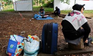 مهاجرون ينتظرون في منطقة استراحة في مجمع مكتب التسجيل في مركز لطالبي اللجوء في منطقة رينكندورف - 6 من تشرين الأول 2023 (رويترز)