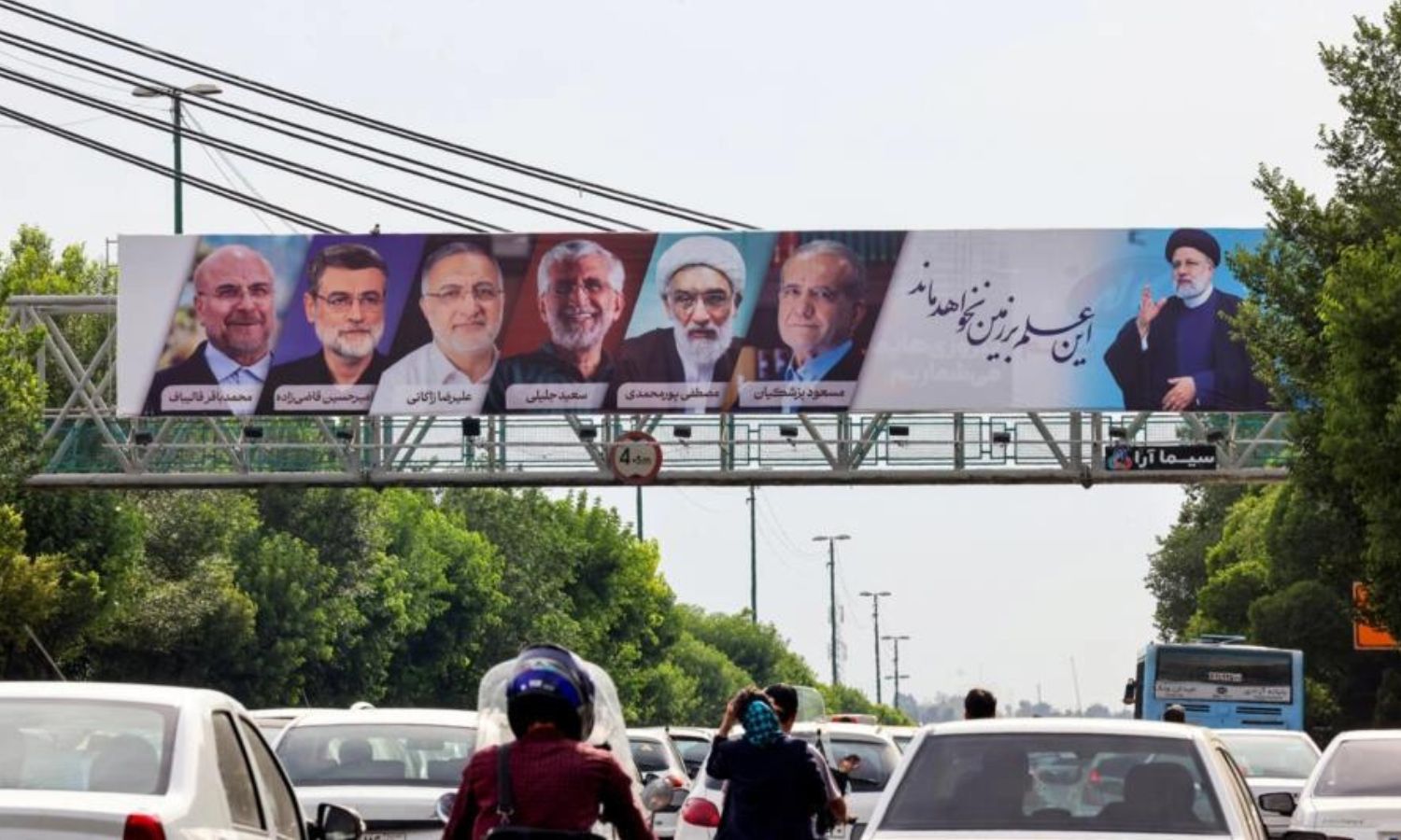لوحة إعلانية تعرض صور المرشحين الستة في الانتخابات الرئاسية الإيرانية المقبلة بالعاصمة الإيرانية طهران- 16 من حزيران 2024 (AFP)