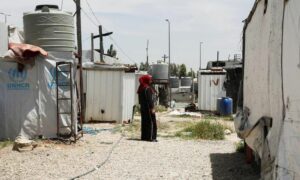 لاجئة سورية تقف بالقرب من خيام في مخيم غير رسمي في وادي البقاع  بلبنان - 23 من أيار 2024 (رويترز) 