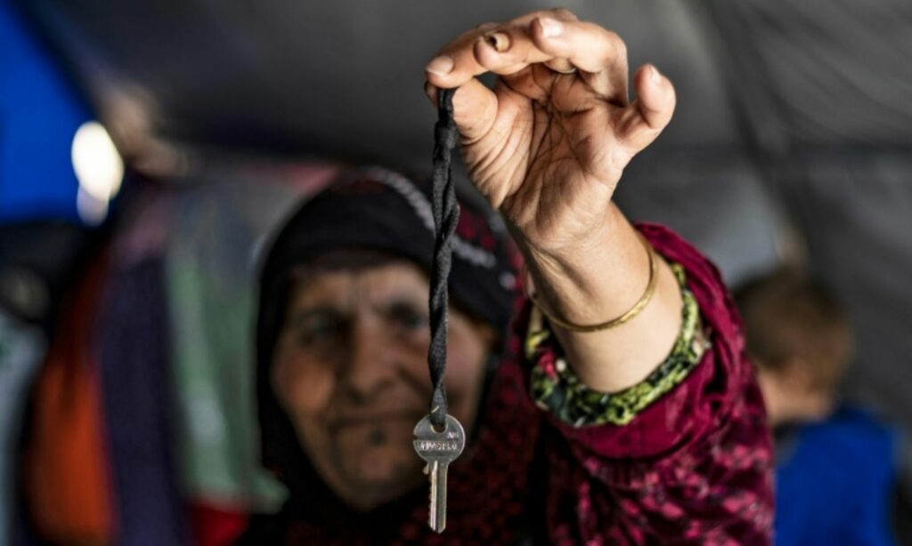 امرأة سورية نازحة من رأس العين وتحمل مفتاح منزلها بعد أن استولي عليه من قبل فصائل عسكرية تابعة لتركيا - 10 من أغسطس 2020 (afp)