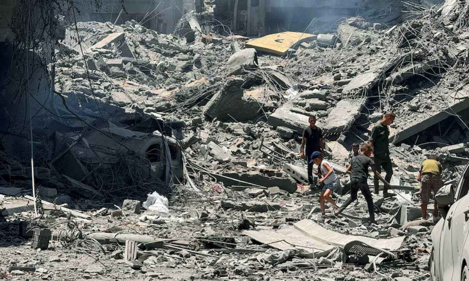 فلسطينيون يبحثون عن ضحايا في مواقع الغارات الإسرائيلية على المنازل في غزة- 22 من حزيران 2024 (رويترز)