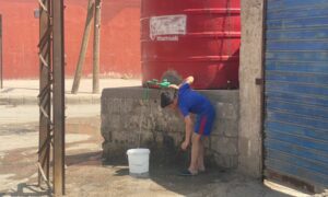 طفل يعبئ الماء من خزان الحي في مدينة الحسكة- أيلول 2023 (عنب بلدي)