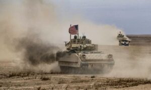 مدرعة قتالية أمريكية من نوع برادلي خلال مناورة عسكرية مشتركة مع قسد في دير الزور السورية- 7 من كانون الأول 2021 (AFP)
