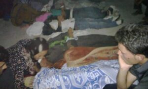جثث قتلى يبكيهم ذووهم في بلدة التريمسة بعد المجزرة_ 12 من تموز 2012 (أرشيف الثورة السورية/ تويتر)