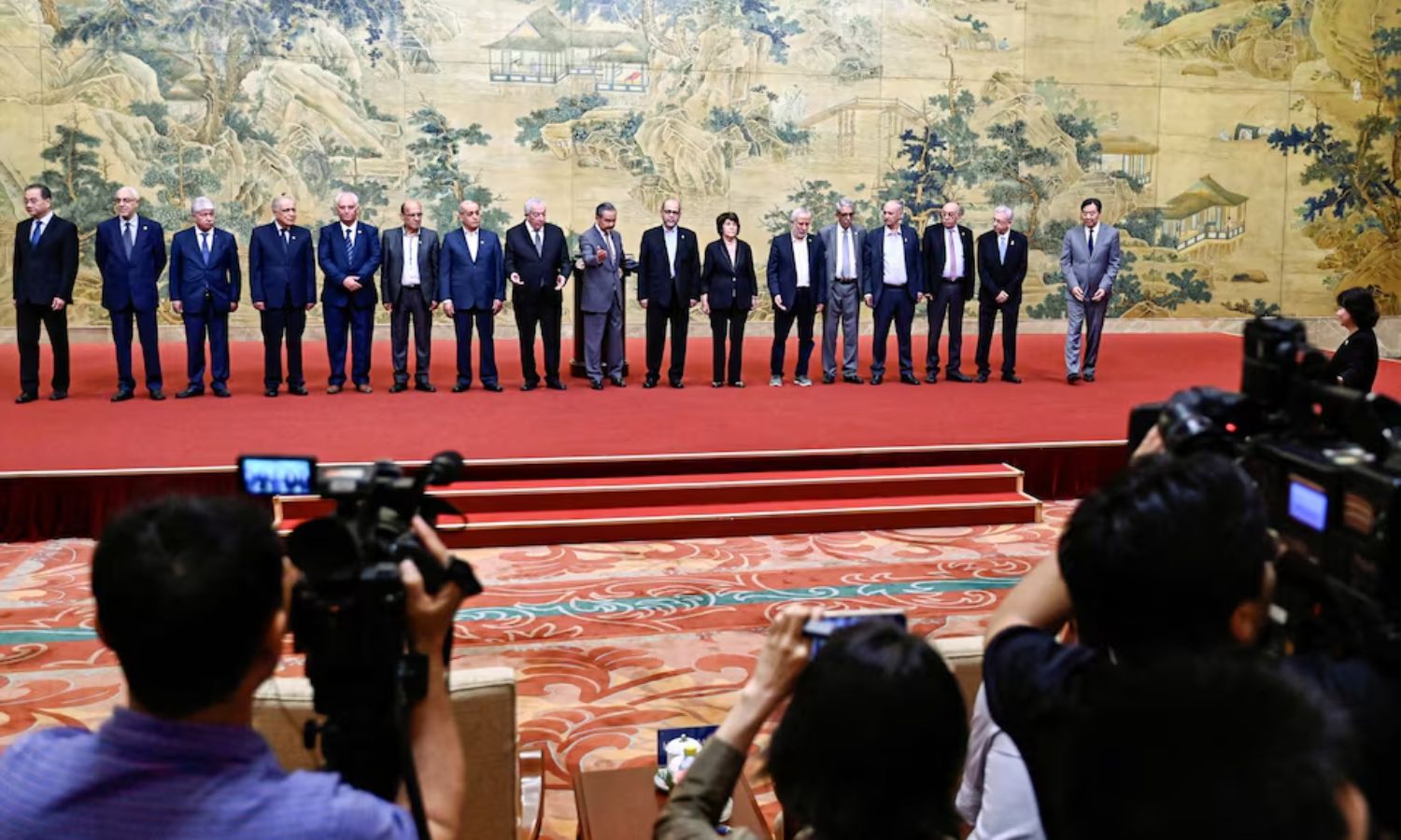 وزير الخارجية الصيني في صورة جماعية مع ممثلين عن الفصائل الفلسطينية في أثناء توقيع "إعلان بكين" في بكين- 23 من تموز 2024 (رويترز)