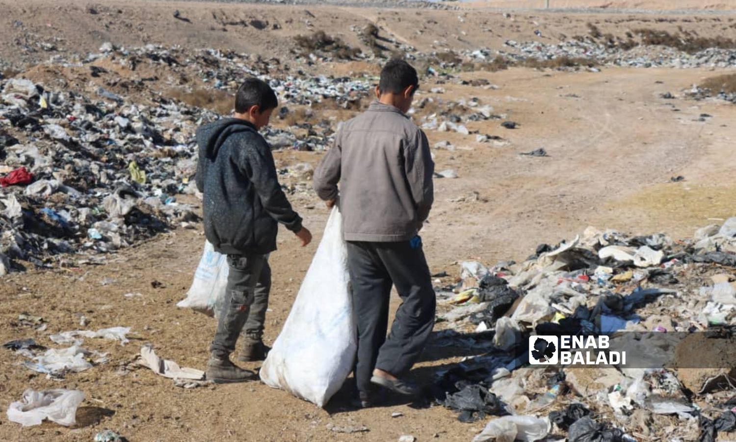 طفل يعمل في جمع الخردوات من مكبات النفايات في ريف دير الزور الشرقي- 15 من آب 2023 (عبادة الشيخ/ عنب بلدي).