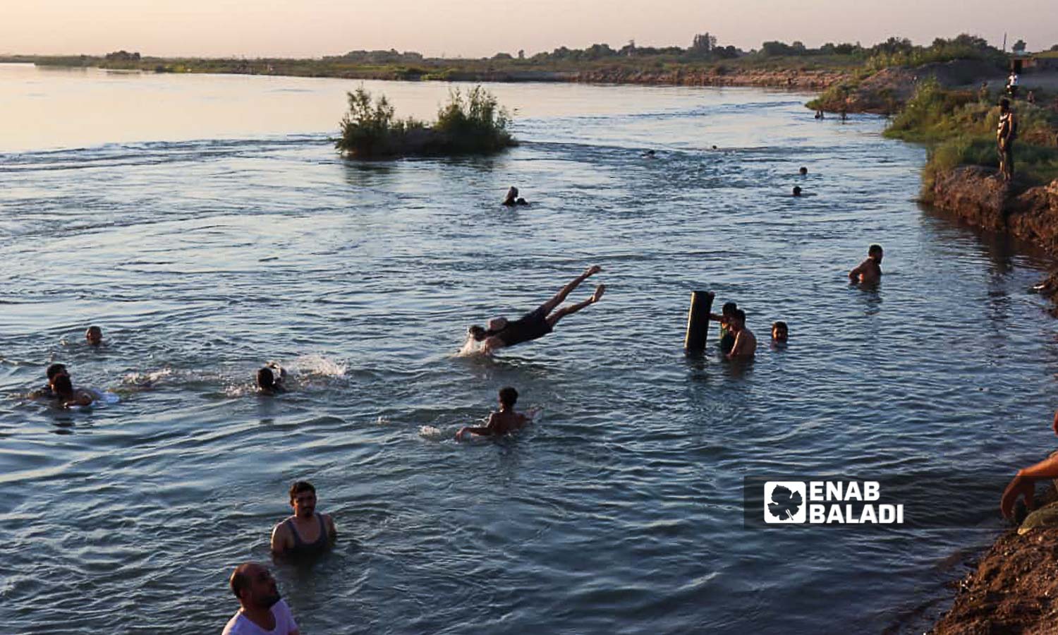شبان يسبحون في نهر الفرات  بريف دير الزور شرقي سوريا - 20 من تموز 2024 (عنب بلدي/عبادة الشيخ)