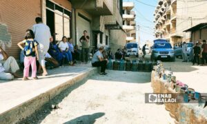 أشخاص ينتظرون في أحد أحياء القامشلي من أجل التسجيل على الغاز المنزلي - 20 من حزيران 2024 (عنب بلدي/ مجد السالم)
