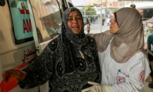 ممرضة تواسي سيدة في مستشفى ناصر بعد مقتل أحد أبنائها بقصف إسرائيلي على خان يونس جنوب قطاع غزة- 22 من تموز 2024 (رويترز)