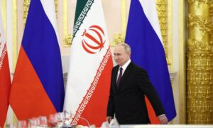 الرئيس الروسي فلاديمير بوتين وخلفه علما روسيا وإيران خلال اجتماع مع الرئيس الإيراني السابق إبراهيم رئيسي- 2023 (رويترز)