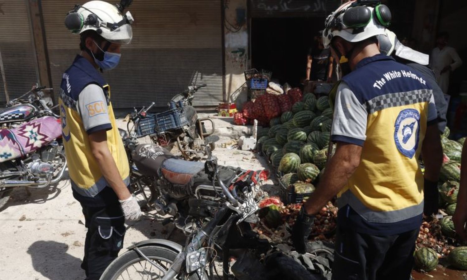 متطوعان في الجيش الوطني السوري يتفقدان موقع انفجار دراجة نارية مفخخة في مدينة عفرين شمالي حلب- 21 من آب 2024 (الدفاع المدني السوري)