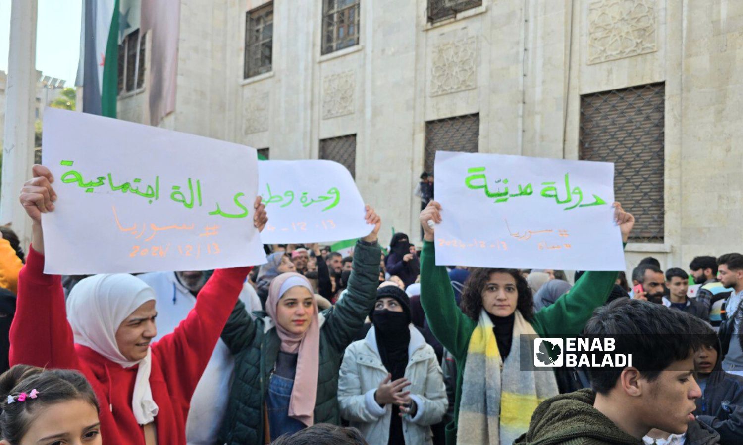 نساء يحملن لافتات في احتفالية سقوط الأسد بحماة - 13 كانون الأول 2024 (عنب بلدي/ إياد عبد الجواد)