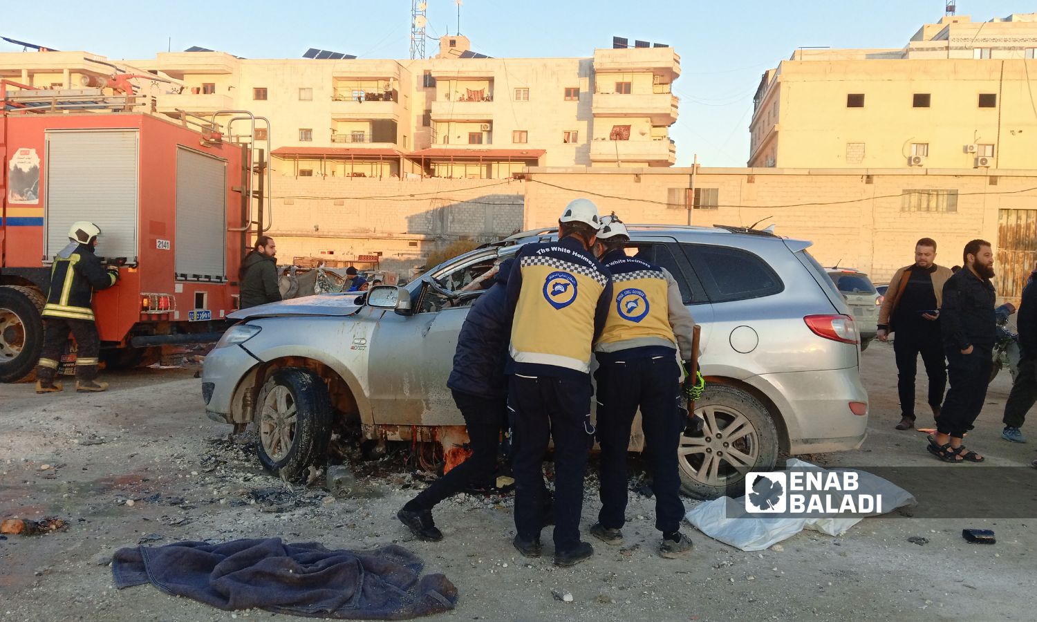 متطوعو "الدفاع المدني السوري" يحاولون استخراج جثة الشخص من السيارة - 21 شباط 2025 (عنب بلدي/ محمد مصطو)