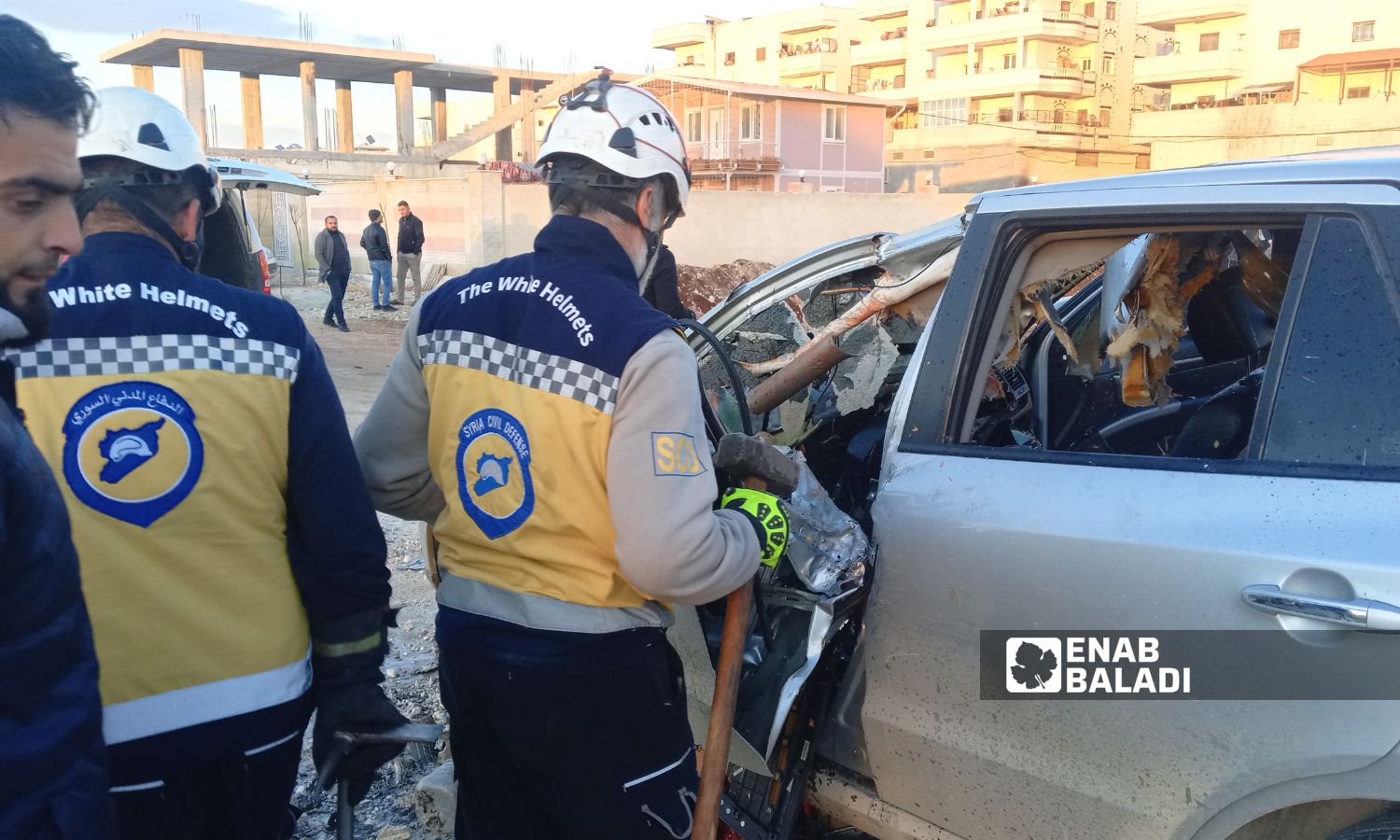 متطوعو "الدفاع المدني السوري" يحاولون استخراج جثة الشخص من السيارة - 21 شباط 2025 (عنب بلدي/ محمد مصطو)