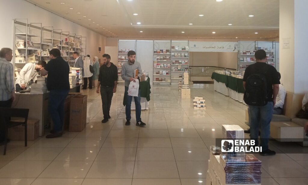 زوار داخل صالة معرض "كتب المركز العربي واصداراته بدمشق" - 28 نيسان 2025 (عنب بلدي/مارينا مرهج)