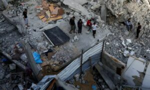 فلسطينيون يتفقدون موقع غارة إسرائيلية على منزل في خان يونس جنوب قطاع غزة- 3 أيار 2025 (رويترز)