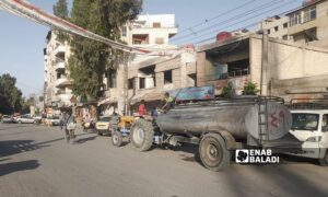 أطفال يعتلون صهريجًا أثناء تعبئته خزان مياه في أشرفية صحنايا بريف دمشق – 14 أيار 2025 (عنب بلدي/ نور حمزة)