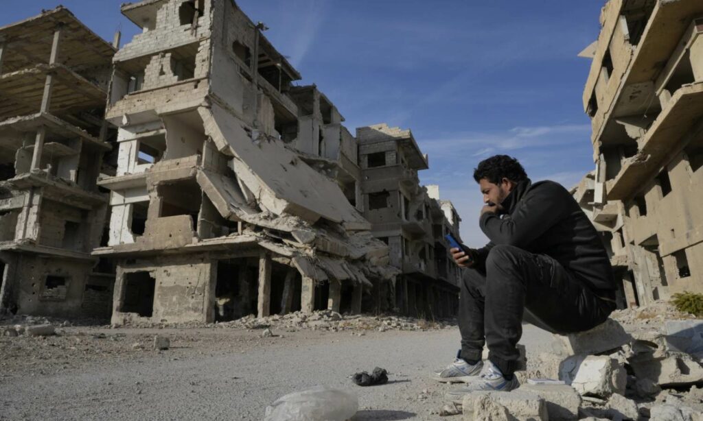 لاجئ فلسطيني- سوري بين ركام المنازل في مخيم اليرموك جنوبي دمشق - 14 كانون الأول 2024 (AP)