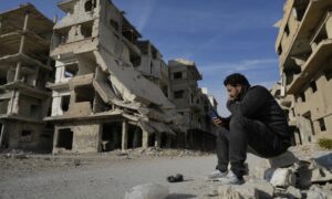 لاجئ فلسطيني- سوري بين ركام المنازل في مخيم اليرموك جنوبي دمشق - 14 كانون الأول 2024 (AP)