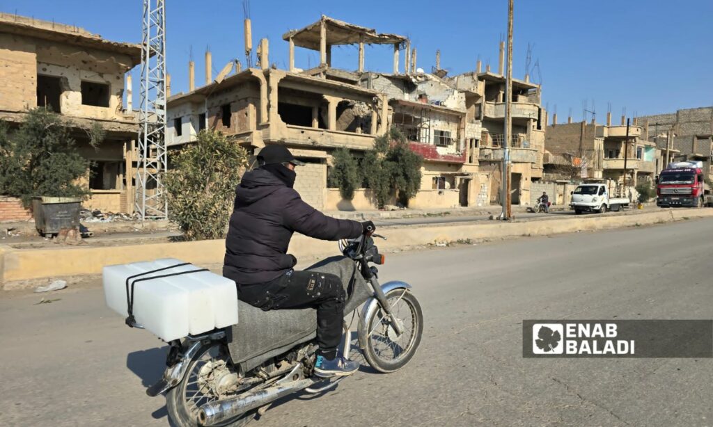شاب يحمل قوالب الثلج على دراجته بحي الرصافة بمدينة دير الزور شرقي سوريا - 11 آذار 2025 (عنب بلدي/ عبادة الشيخ)