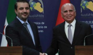 وزير الخارجية السوري  أسعد الشيباني ونظيره العراقي فؤاد حسين يلتقطان صورة للكاميرات خلال مؤتمرهما الصحفي المشترك 14 من آذار 2025 (أحمد الروبية / أ.ف.ب)