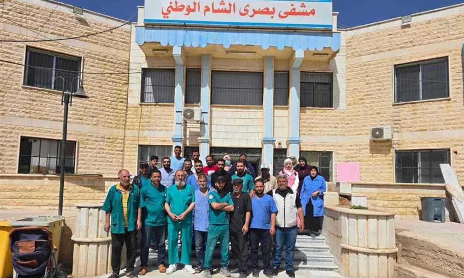 كادر مستشفى بصرى الشام الوطني في أثناء إعلانه بيان تعليق عمله- 19 أيار 2025 (عمران العيسى/ فيسبوك)