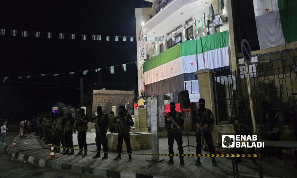 عناصر من الأمن العام أمام مبنى مديرية التربية بمحافظة دير الزور لحماية الاحتفالية بذكرى الثورة السورية - 16 آذار 2025 (عنب بلدي/ عبادة الشيخ)