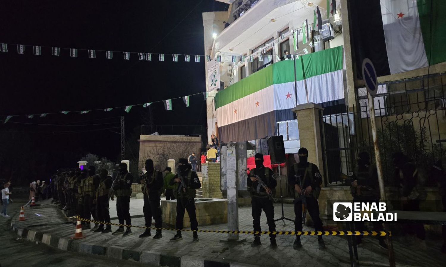 عناصر من الأمن العام أمام مبنى مديرية التربية بمحافظة دير الزور لحماية الاحتفالية بذكرى الثورة السورية - 16 آذار 2025 (عنب بلدي/ عبادة الشيخ)