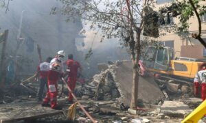 فرق الإنقاذ تعمل في موقع بناء تعرض للقصف الإسرائيلي في طهران 13 حزيران 2025 (رويترز)