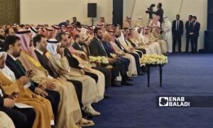 الرئيس السوري للمرحلة الانتقالية أحمد الشرع إلى جانب شخصيات حكومية ورجال أعمال سوريين وسعوديين - 24 تموز 2025 (عنب بلدي)