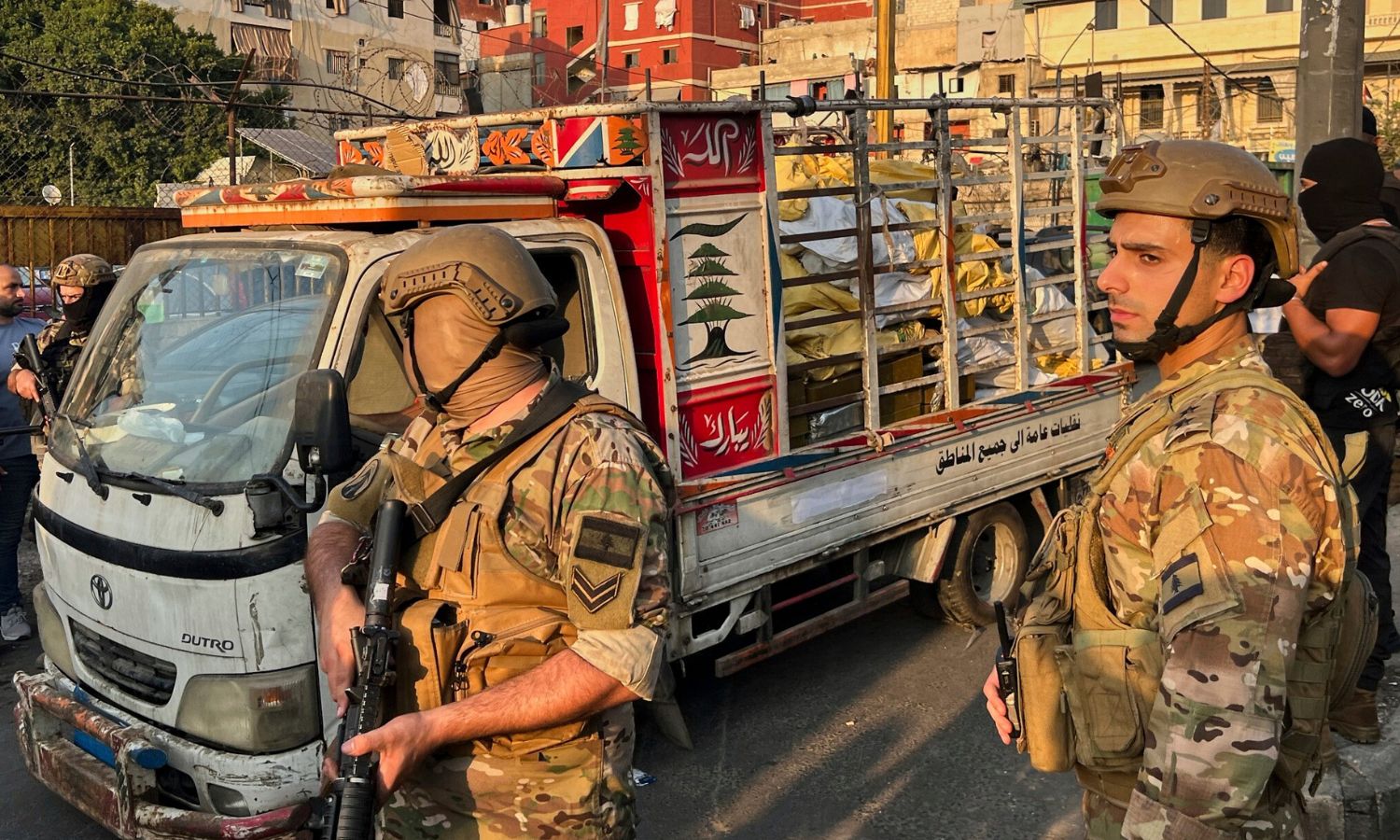جنود من الجيش اللبناني يقفون بجوار شاحنة صغيرة تحمل أسلحة سلمتها الفصائل الفلسطينية في مخيم برج البراجنة للاجئين الفلسطينيين في بيروت - 21 آب 2025 (AP/حسين ملا)