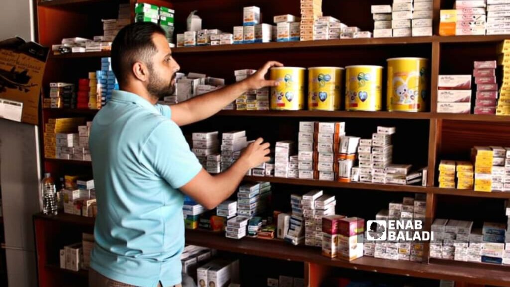 صيدلي أمام علب حليب سورية في أحد صيدليات مدينة رأس العين - 25 أيلول 2025 (عنب بلدي)