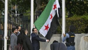 وزير الخارجية السوري أسعد الشيباني يرفع علم سوريا في مقر الأمم المتحدة في نيويورك - 25 نيسان 2025 (AFP)
