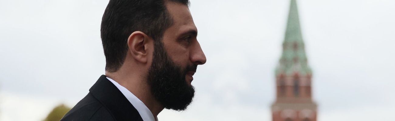 الرئيس السوري في المرحلة الانتقالية أحمد الشرع يقف أمام مبنى الكرملين في موسكو - 15 تشرين الأول 2025 (تاس)
