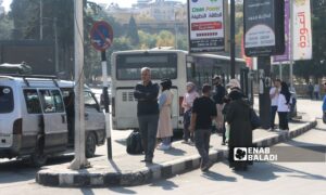 تجمع للأهالي عند موقف للسرافيس والباصات في ساحة الجامعة وسط مدينة حلب- 11 تشرين الأول 2025 (عنب بلدي/ محمد مصطو)
