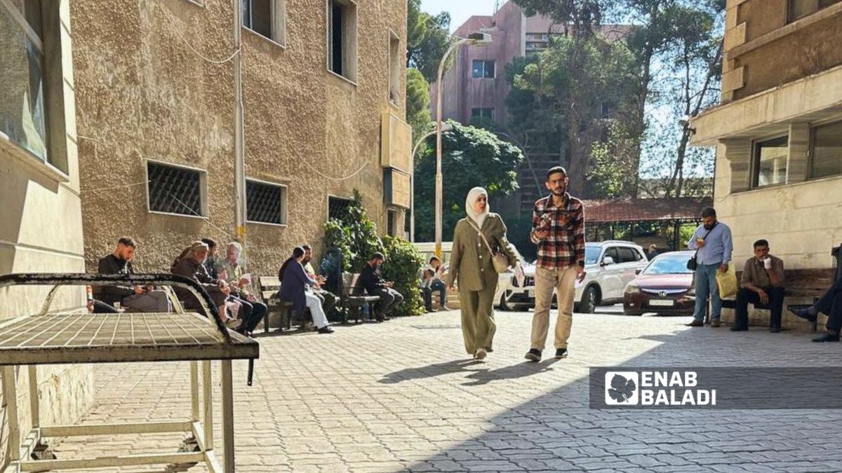 زوار ومرضى في ساحة مستشفى "المجتهد" المعروف بمستشفى دمشق - 13 تشرين الأول 2025 (عنب بلدي/ أحمد الحمود)