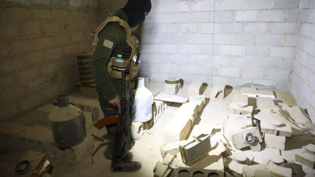 أحد عناصر الأمن العام يتفقد الأسلحة المضبوطة في مستودع بمنطقة البوكمال في ريف دير الزور الشرقي - 28 تشرين الأول 2025 (محافظة دير الزور)