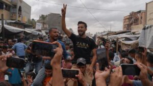 يحتفل الفلسطينيون عقب الإعلان عن موافقة حماس وإسرائيل على المرحلة الأولى من خطة السلام لوقف القتال، في خان يونس، جنوب قطاع غزة، 9 تشرين الأول 2025 (أسوشيتد برس/جهاد الشرفي)