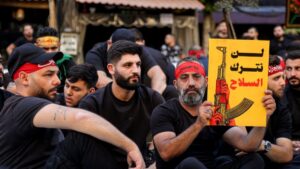 أحد أنصار حزب الله يرفع لافتة مكتوب عليها لن نترك السلاح في مظاهرة بالضاحية الجنوبية 7 تموز 2025 (د. ب. أ)