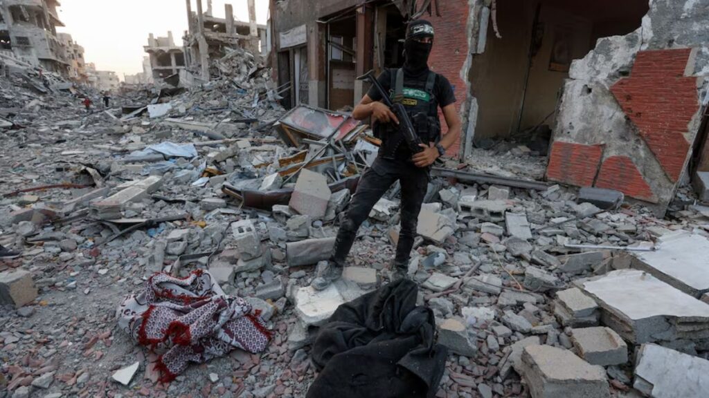 مقاتل فلسطيني يقف عند منطقة بحث عن رفات رهائن إسرائيليين في غزة - 4 تشرين الثاني 2025 (رويترز/داوود أبو الكاس)