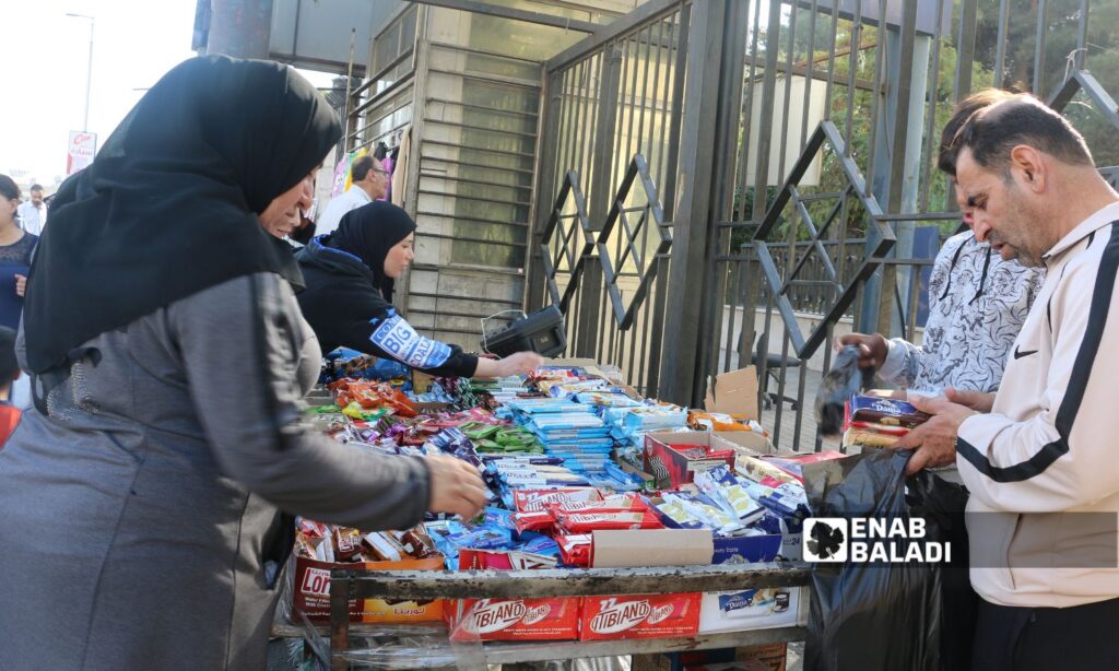 سوريون يتسوقون من بسطة بسكويت في دمشق - 1 تشرين الأول 2025 (عنب بلدي/أنس حاج حسن)