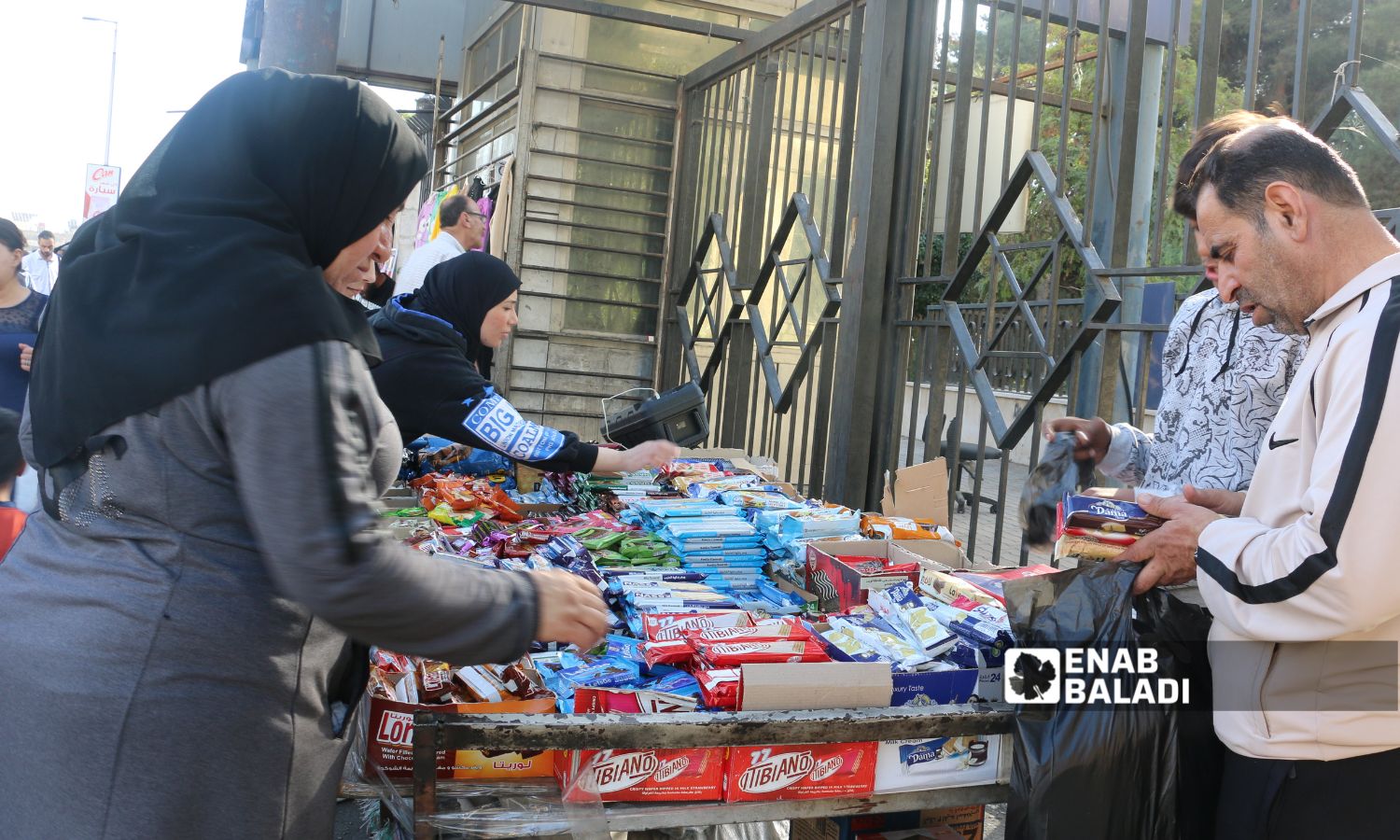سوريون يتسوقون من بسطة بسكويت في دمشق - 1 تشرين الأول 2025 (عنب بلدي/أنس حاج حسن)